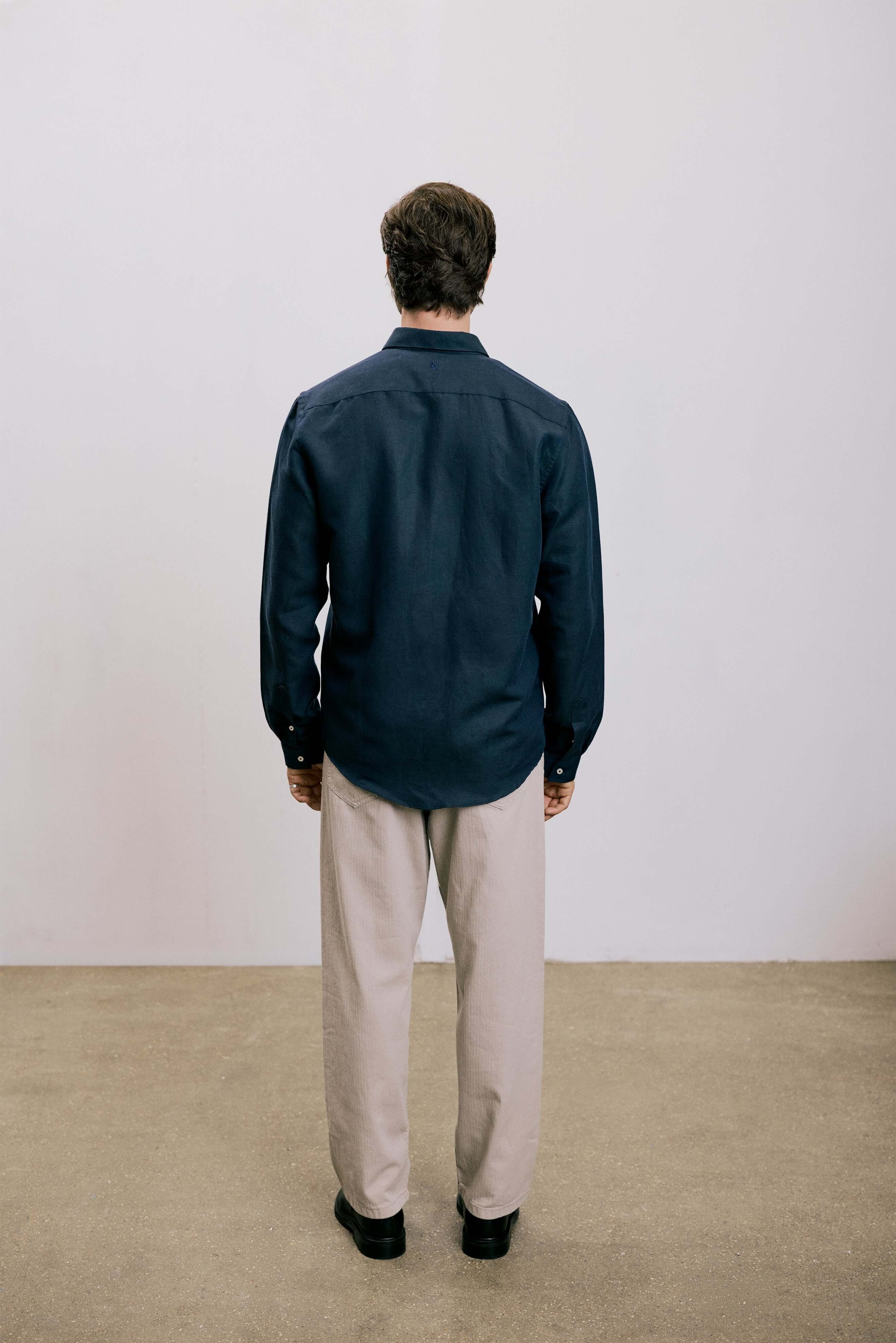 Back view of a man wearing the VARRO Evelyn Midnight Navy shirt in hemp cotton merino blend with relaxed fit and hidden button-down collar.