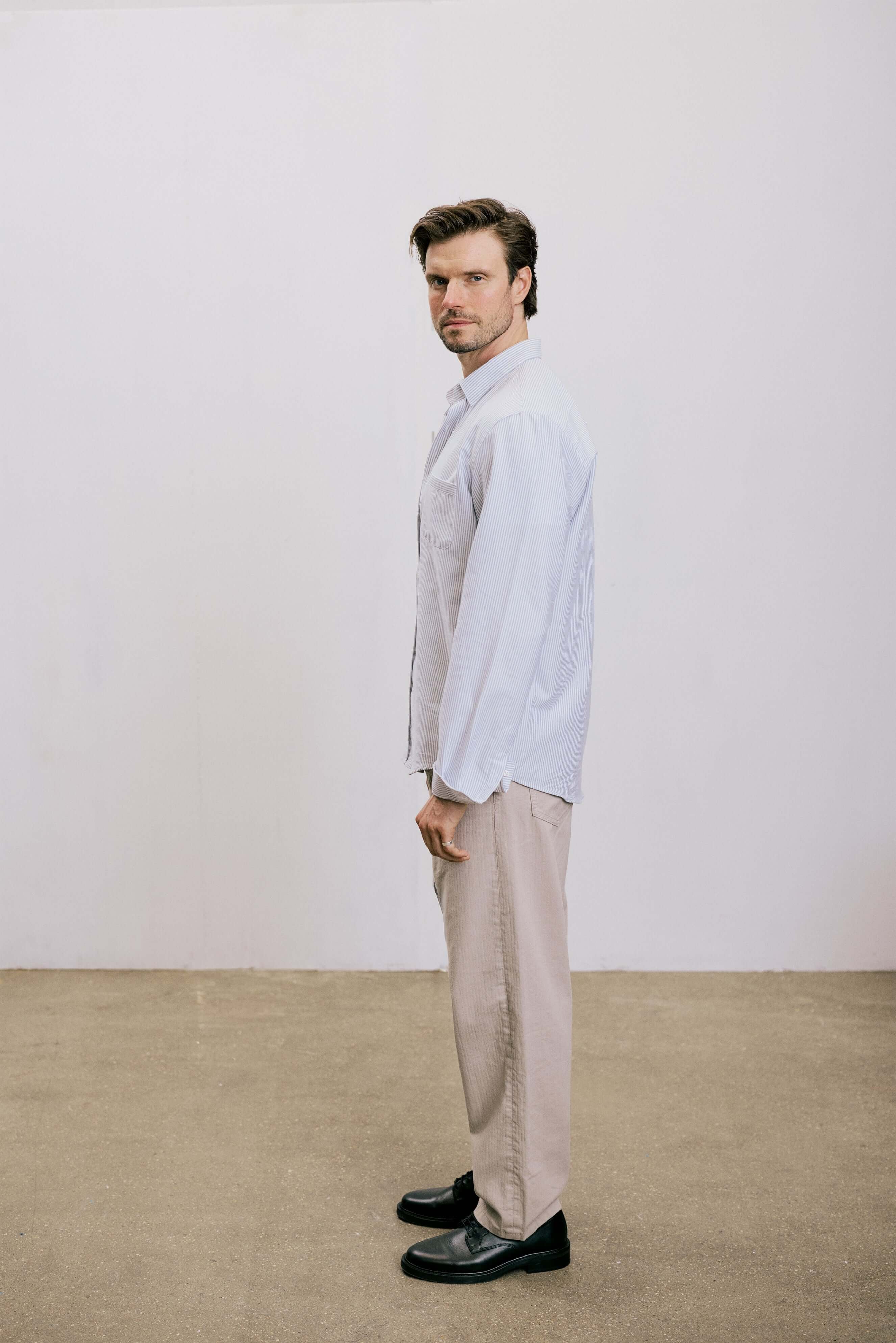 VARRO Keble Navy Stripe Oxford Shirt — Side view of a man wearing relaxed fit long sleeve shirt with hidden button-down collar.