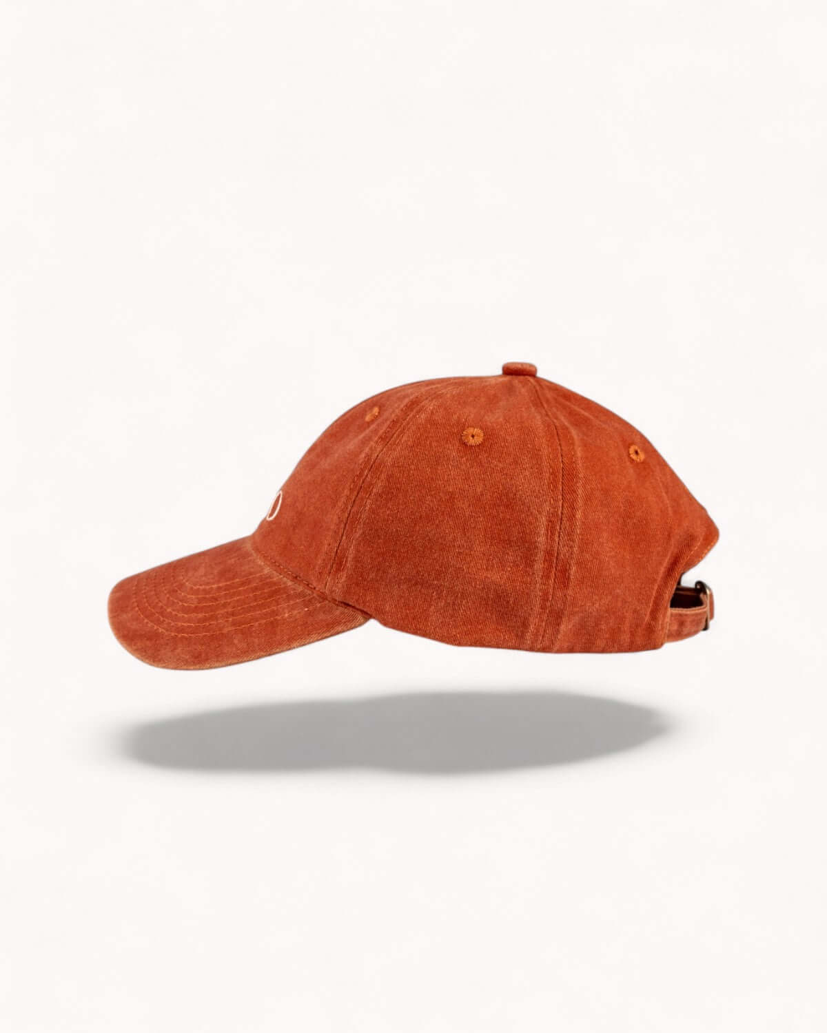 Left side profile of Ember Orange cap showing washed fabric texture