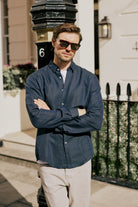 Man wearing VARRO Evelyn Midnight Navy shirt with hidden button-down collar, relaxed fit, standing outdoors.